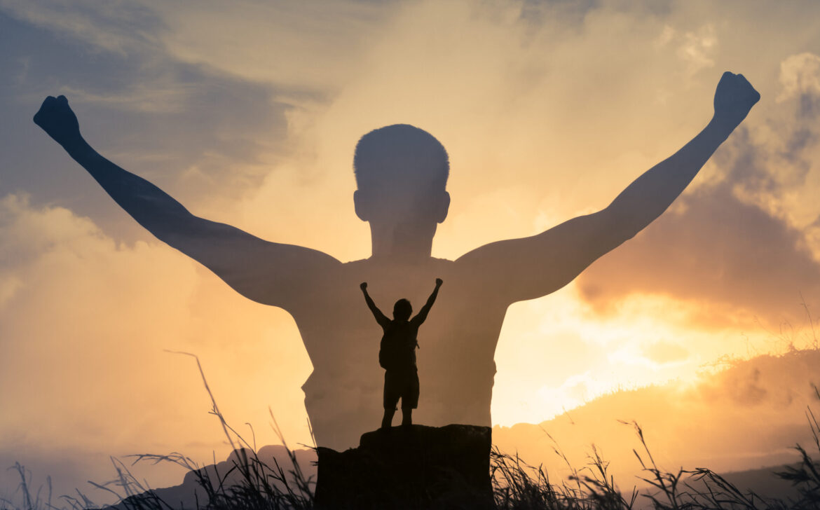 Strong,Man,On,A,Mountain,Top,With,Arms,Flexed,Facing